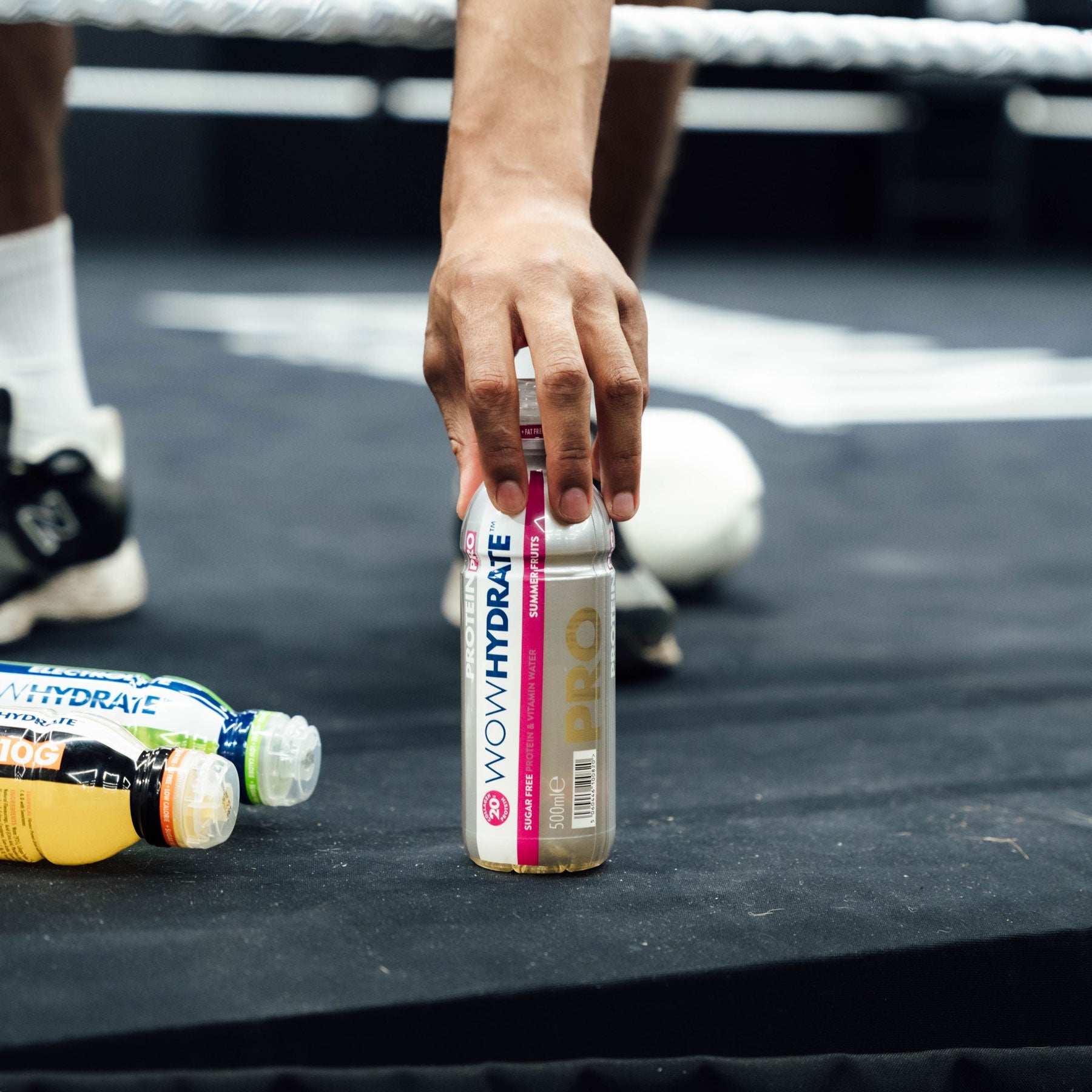 wowhydrate protein pro bottle being picked up on the side of a boxing ring